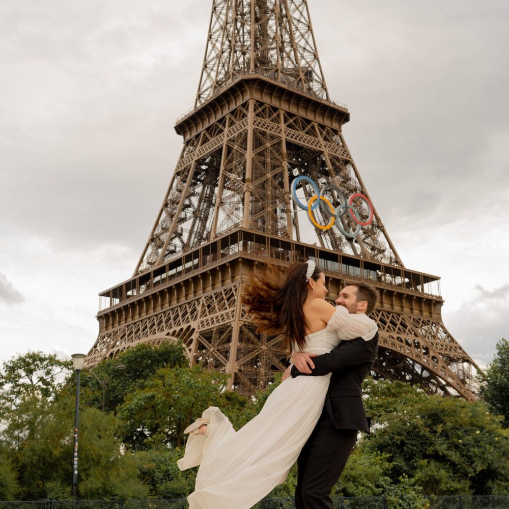Bruid en bruidegom omhelzen elkaar teder met de Eiffeltoren op de achtergrond, vastgelegd in zacht natuurlijk licht. door Lavender Photography. bruiloft fotograaf. trouwfotograaf. fotograaf bruiloft. fotograaf buiten bruiloft. huwelijksfotograaf. wedding fotograaf. loveshoot fotograaf Professionele bruiloftsfotograaf