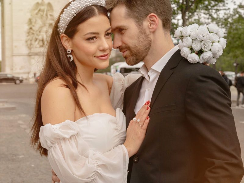 Bruid en bruidegom omhelzen elkaar teder met de Eiffeltoren op de achtergrond, vastgelegd in zacht natuurlijk licht. door Lavender Photography. Professionele bruiloftsfotograaf