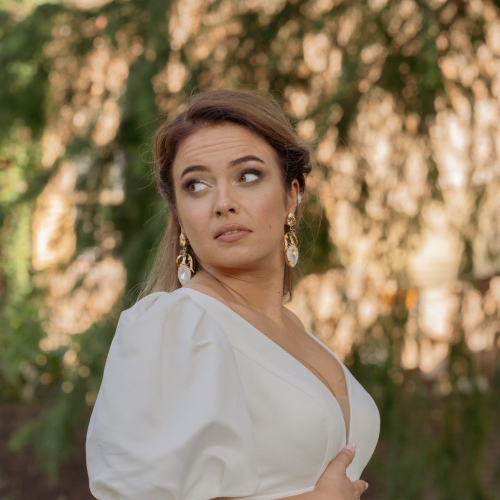 Lachende bruid in witte trouwjurk poseert buiten, omringd door bomen. door Lavender Photography. bruiloft fotograaf . trouwfotograaf . fotograaf bruiloft . fotograaf buiten bruiloft . huwelijksfotograaf . wedding fotograaf . loveshoot fotograaf Professionele bruiloftsfotograaf